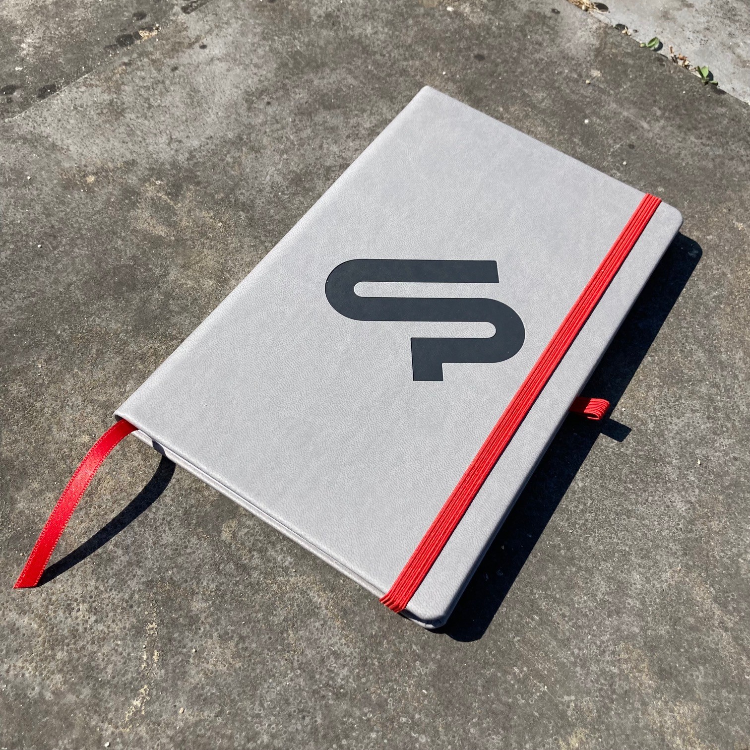 Notitieboek Mix&Match grijs PU met eigen logo en rood elastiek